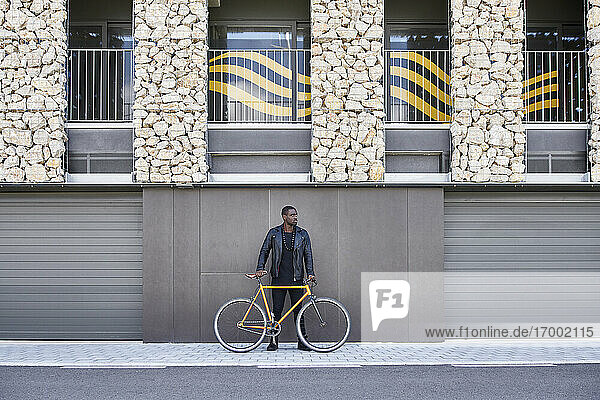 Mann mit Fahrrad auf dem Bürgersteig