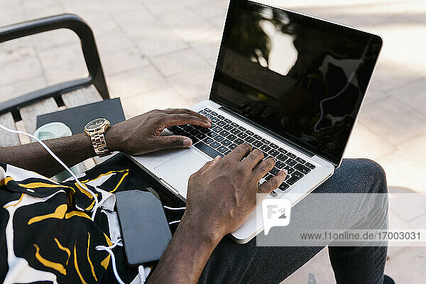 Hände eines männlichen Unternehmers  der auf einem Laptop tippt