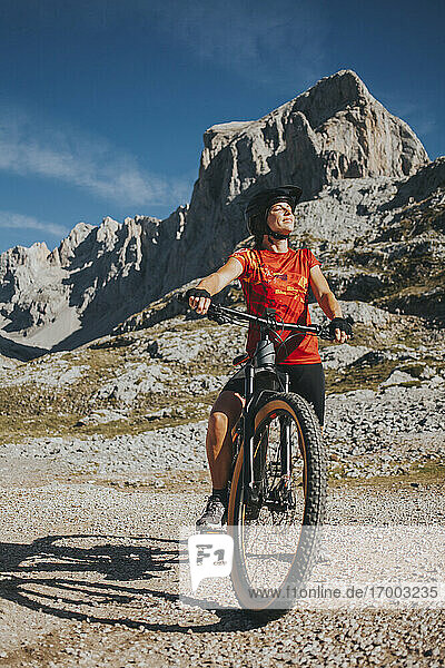 Lächelnde Radfahrerin mit geschlossenen Augen auf dem Fahrrad im Nationalpark Picos de Europa  Kantabrien  Spanien