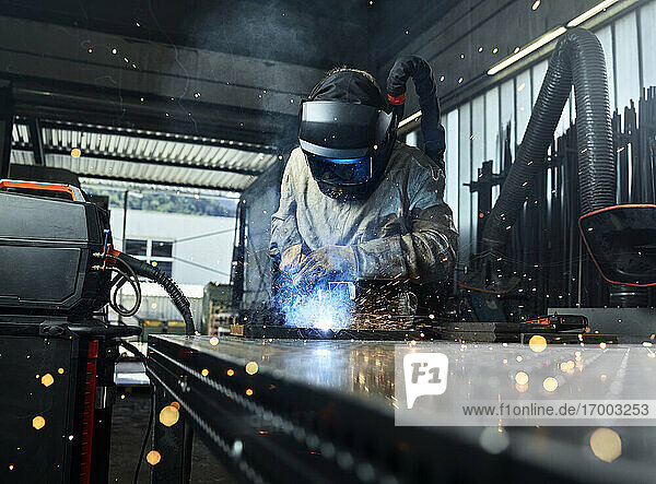 Metallarbeiter in Arbeitsschutzkleidung beim Schweißen von Metall in einer Fabrik
