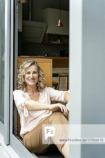 Glückliche Unternehmerin sitzt am Eingang einer Büro-Cafeteria
