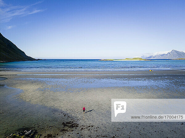 Frau steht am Strand von Fredvang  Lofoten  Norwegen