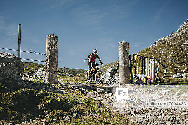 Radfahrerin beim Überqueren der Grenze zwischen Canatabrien und Asturien im Nationalpark Picos de Europa  Kantabrien  Spanien