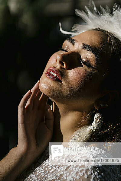 Beautiful bride with eyes closed on sunny day