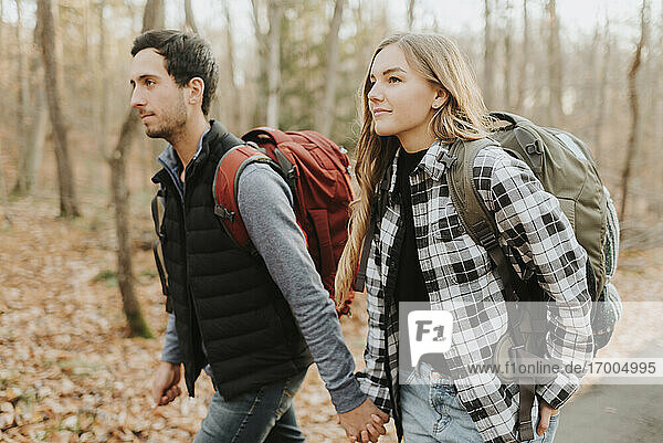 Young couple holding hands during autumn hike
