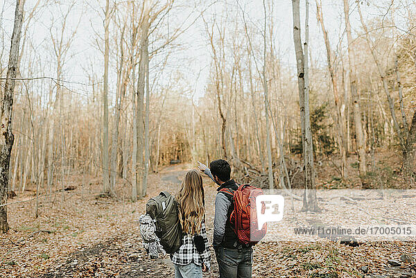 Junges Paar bei Herbstwanderung im Wald stehend