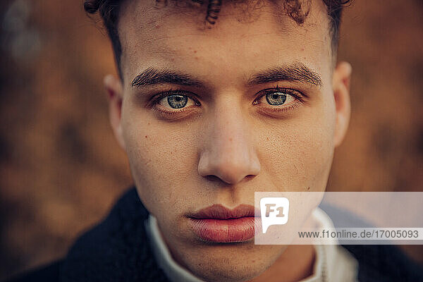 Junger Mann mit blauen Augen im Herbstwald
