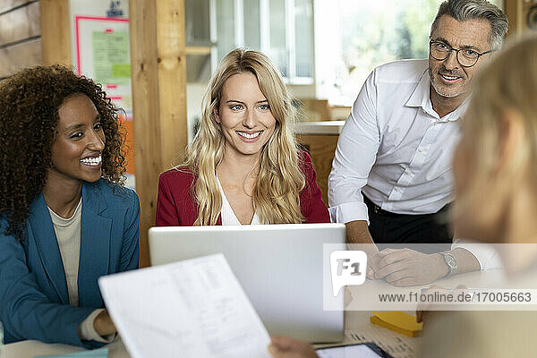 Das Team lächelt  während es in einer Sitzung zusammenarbeitet  während es im Büro sitzt