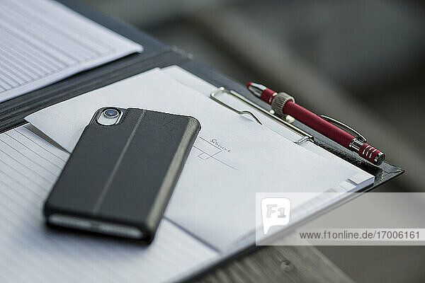 Zwischenablage mit Smartphone und Stift auf dem Schreibtisch