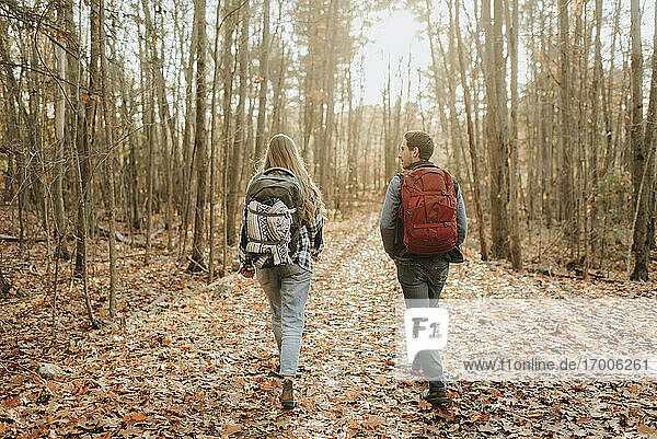 Junges Paar beim Wandern mit Rucksäcken im Herbstwald