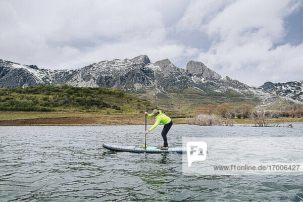 Älterer Mann paddelt auf einem See gegen bewölkten Himmel  Leon  Spanien