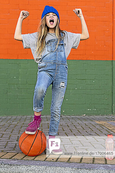 Young girl with foot on basketball
