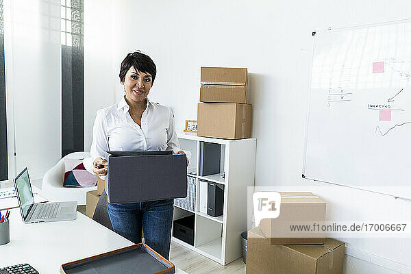 Porträt einer Geschäftsfrau  die ihr Büro vor dem Umzug organisiert