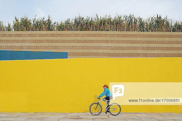 Mann fährt mit dem Fahrrad gegen eine gelbe Wand