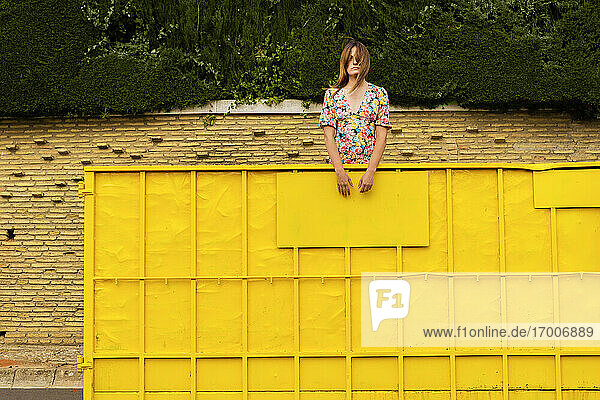 Frau steht im gelben Container und schaut sich um