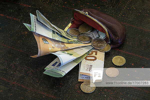 Old fashioned wallet with Euro coins and banknotes