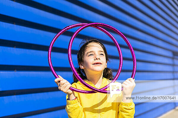 Portrait of little girl with gymnastic rings looking up