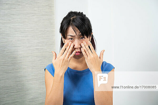 Asiatische Frau mit Nasennebenhöhlenentzündung.