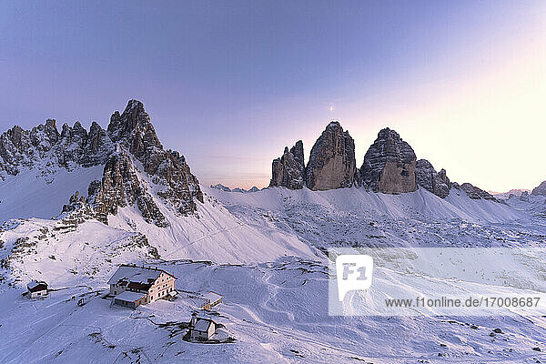 Sonnenuntergang über dem Monte Paterno  den Drei Zinnen und der verschneiten Locatelli-Hütte  Sextner Dolomiten  Südtirol  Italien  Europa