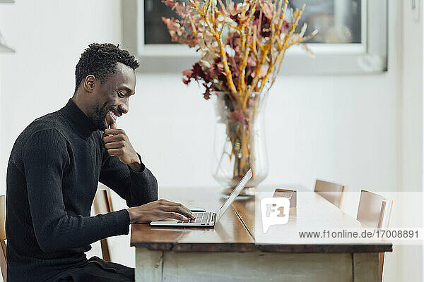 Junger Unternehmer arbeitet am Laptop  während er in einem Café sitzt
