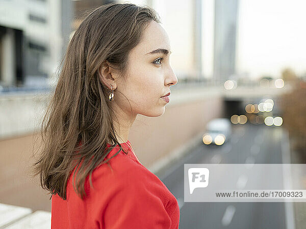 Thoughtful woman looking away in city