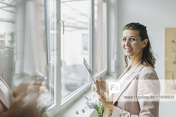 Porträt einer lächelnden Geschäftsfrau mit digitalem Tablet im Büro