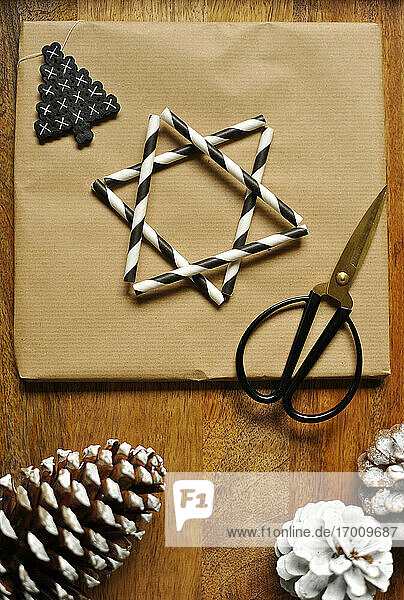Geschenkpapier verziert mit einem Stern aus gestreiften Trinkhalmen