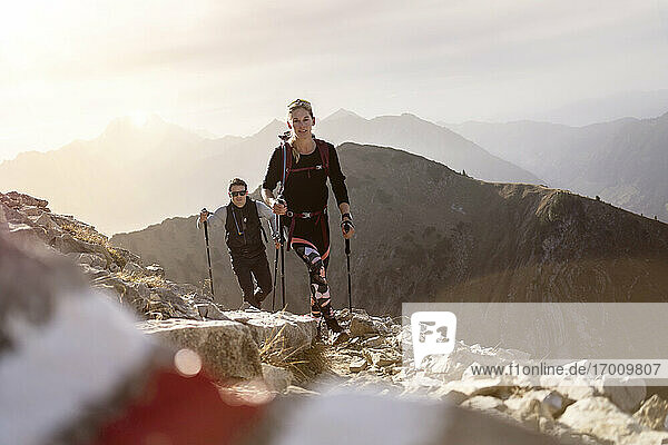 Sportler und Frau mit Wanderstock und Rucksack auf dem Bergpfad des Bschiesser in Tirol  Österreich