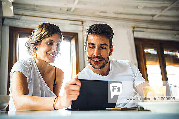 Young couple watching tablet at home