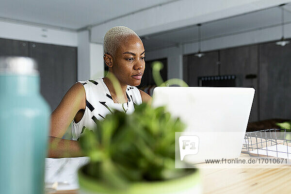 Geschäftsfrau,  die in einem modernen Büro arbeitet und einen Laptop benutzt