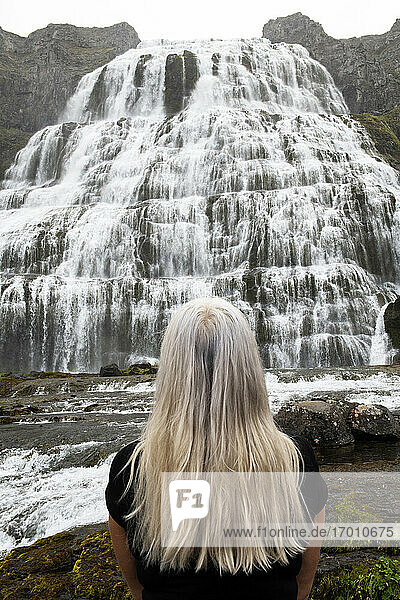 Frau mit Blick auf den Dynjandi-Wasserfall in den Westfjorden  Island