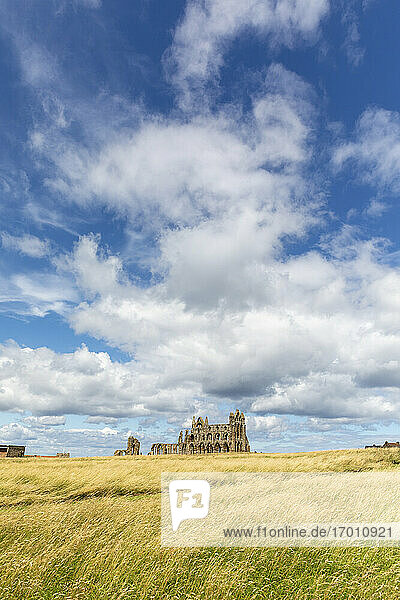 Distant view of Whitby abbey against cloudy sky during sunny day  Yorkshire  UK