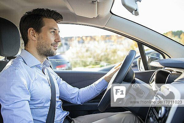 Male entrepreneur sitting in car on sunny day