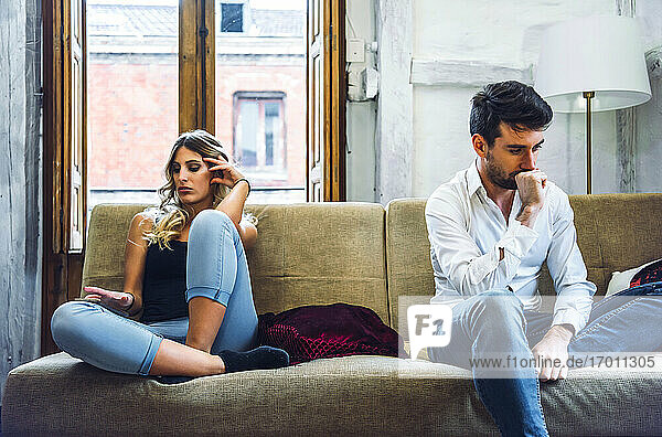 Ehepaar sitzt auf dem Sofa und ist nach einem Streit verärgert