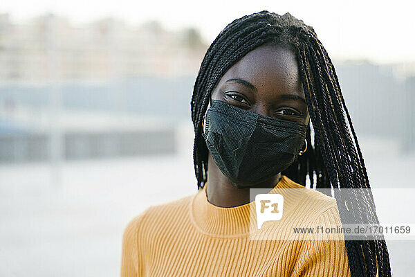 Teenage girl wearing protective face mask outdoors