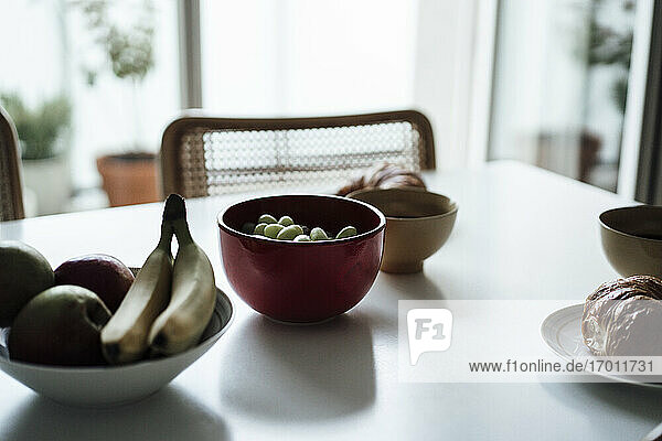 Früchte und Croissant in einer Schale auf dem Esstisch in der Wohnung