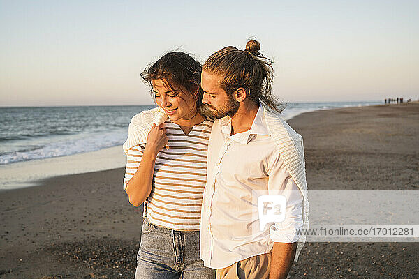 Romantisches junges Paar  das im Urlaub am Strand spazieren geht