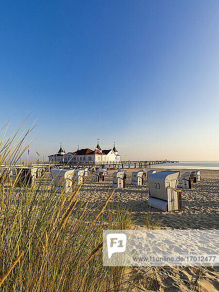 Germany  Mecklenburg-Western Pomerania  Ahlbeck  Hooded beach chairs on sandy coastal beach with bathhouse in background