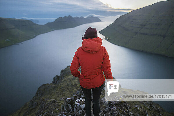 Dänemark  Färöer Inseln  Gjgv  Frau steht auf Klakkur Berg und schaut auf Fjord