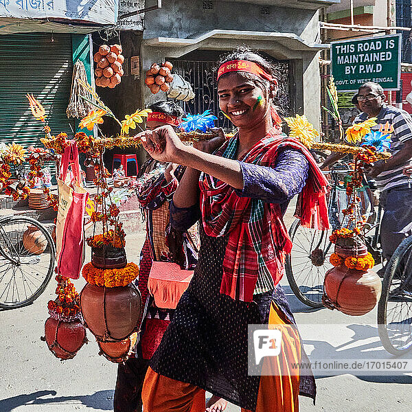 Kalna  Westbengalen  Indien. Typische Atmosphäre im Zentrum mit einer bunten und blumigen Prozession für das Holi-Fest  ein Fest der Farben für den Frühling. Die Opfergaben sind alle von indischen Nelkenketten umgeben.