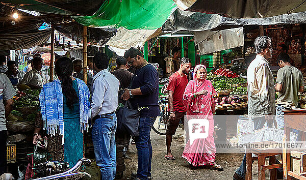 Chandannagar  West Bengal  India. People are passing by a market street while various vendors are selling assorted varieties of food  fruits and green groceries on their stalls in the old city of Chandannagar