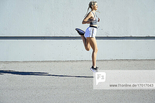 Junge Sportlerin läuft an einem sonnigen Tag gegen die Wand