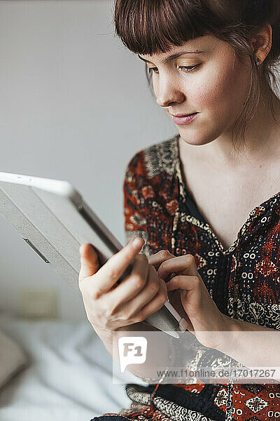 Frau lernt Online-Tutorial auf digitalem Tablet zu Hause
