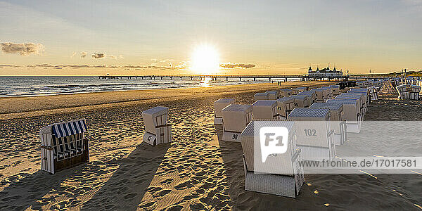 Germany  Mecklenburg-Western Pomerania  Ahlbeck  Hooded beach chairs on sandy coastal beach at sunrise