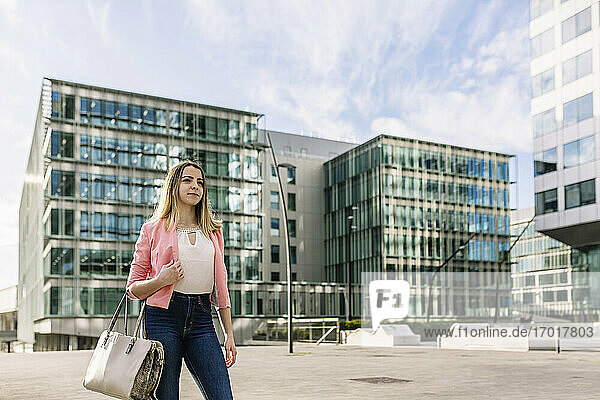 Spanien  Barcelona  Junge Geschäftsfrau vor einem Bürogebäude