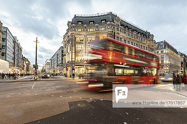 UK  London  Red double decker bus crossing Oxford Circus junction at dusk  blurred