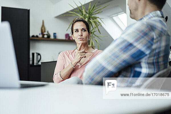 Mature woman contemplating while looking at man in home