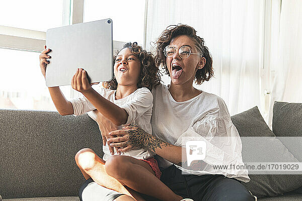 Mutter und Tochter machen Grimassen vor einem digitalen Tablet
