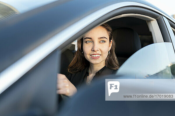 Businesswoman smiling while driving car
