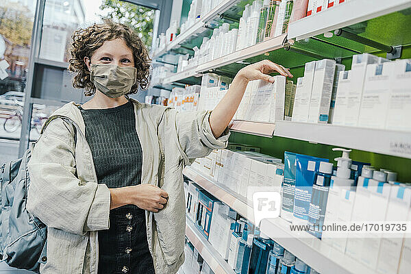 Weibliche Kundin mit Gesichtsschutzmaske in einer Apotheke